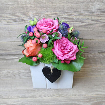 Romantic pastel arrangement in a wooden box with a heart