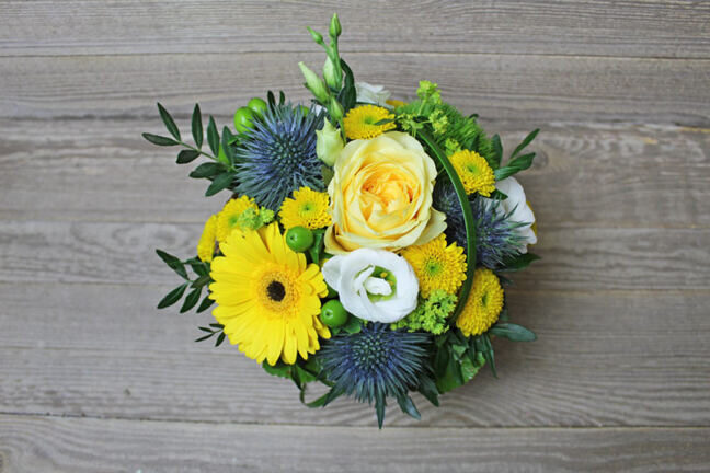 Small yellow flower arrangement in basket